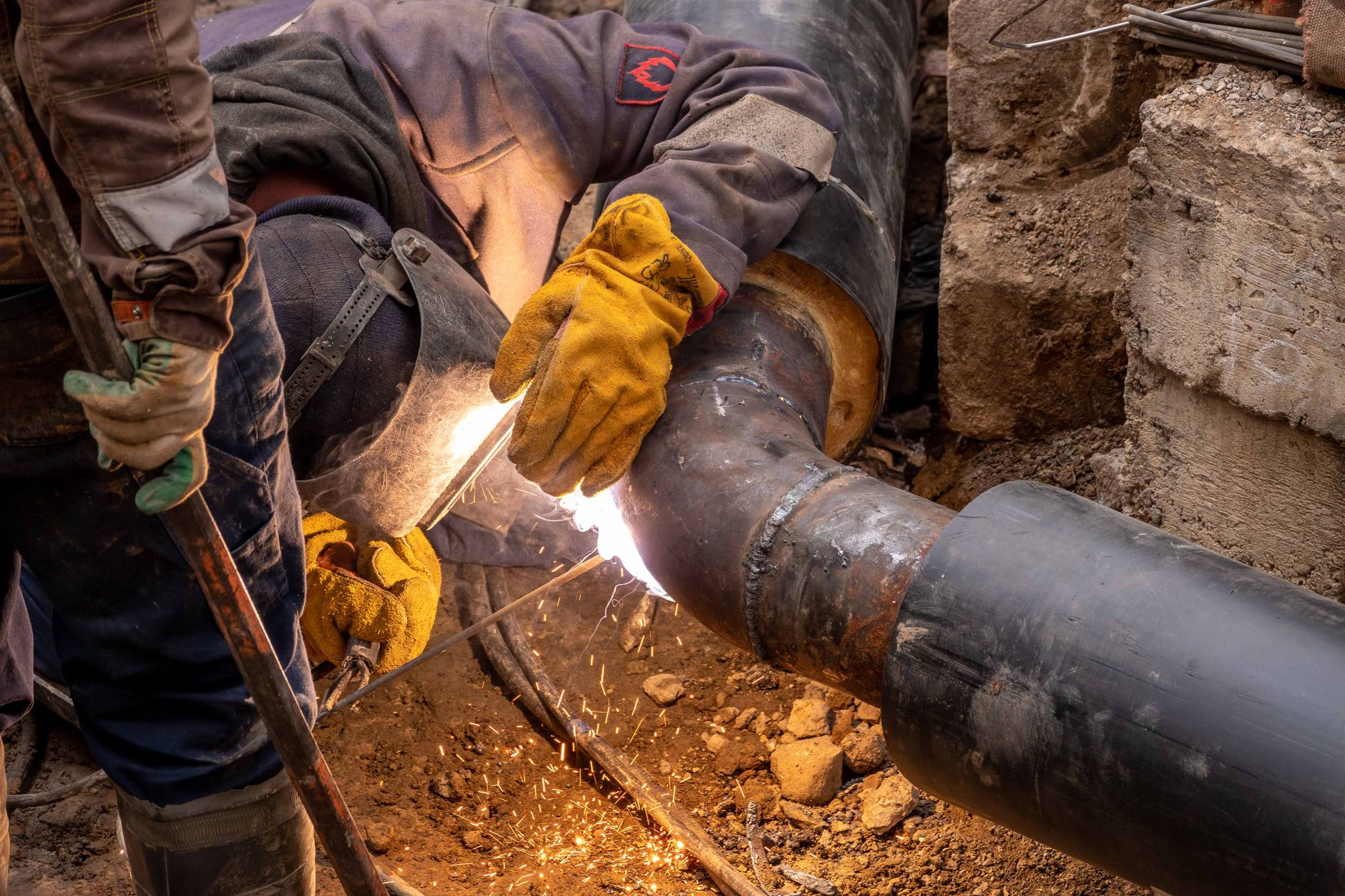 Soldadura de tubería en zanja durante instalación de matriz sanitaria